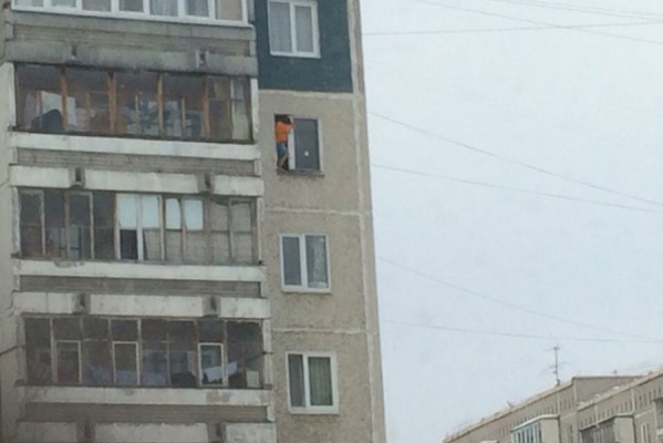 На Синих Камнях, свесив ноги из окна квартиры на восьмом этаже, сидит ребенок - Фото 1