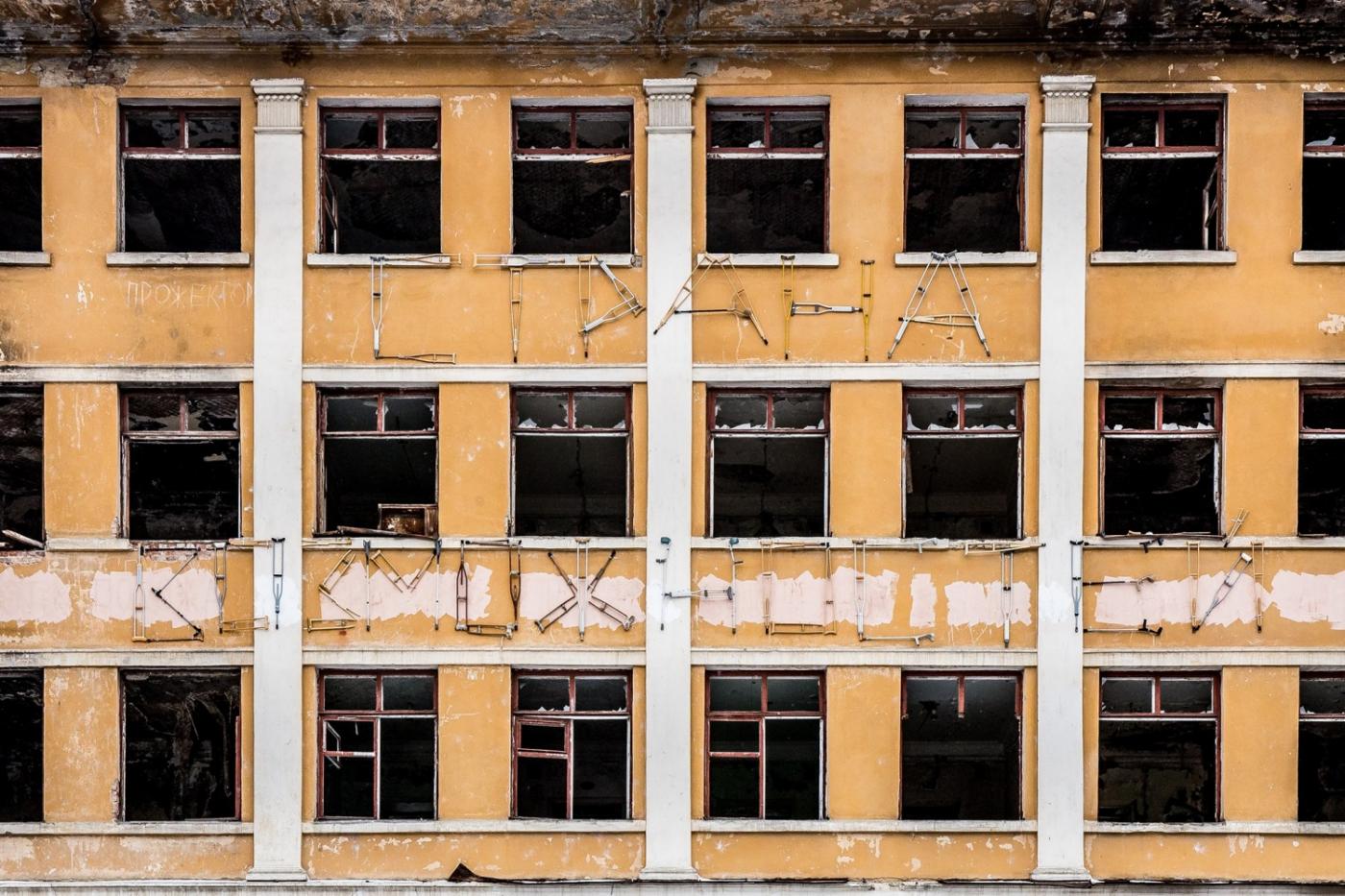 Фасад заброшенной больницы в Зеленой роще «украсили» костылями - Фото 1